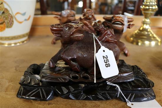 Japanese carved hardwood water buffalo, with rider and stand, two similar larger carvings (a.f.) & another stand